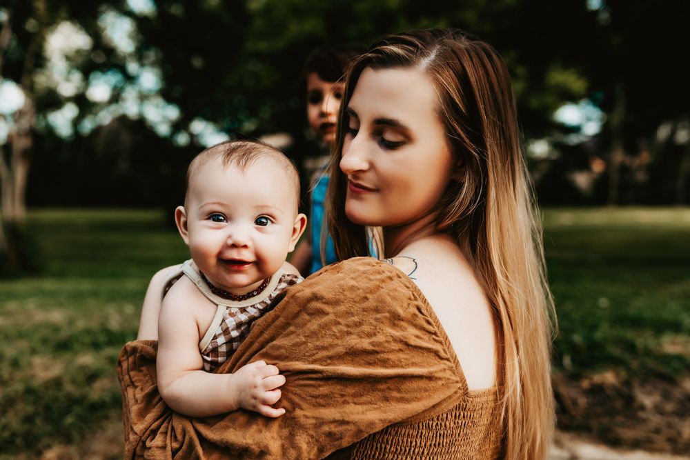 Warm toned outdoor portrait with brown knit wrap in natural lighting.