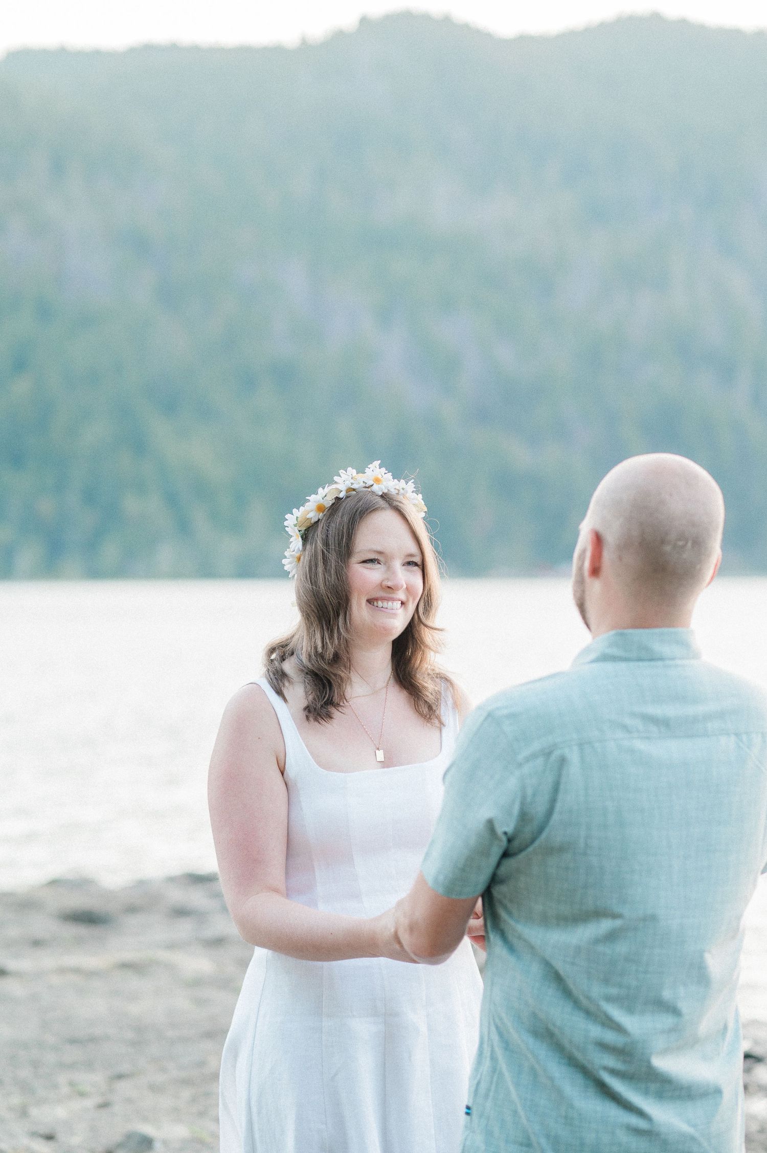 A couple shares a romantic moment together on a lake with mountains in the background.