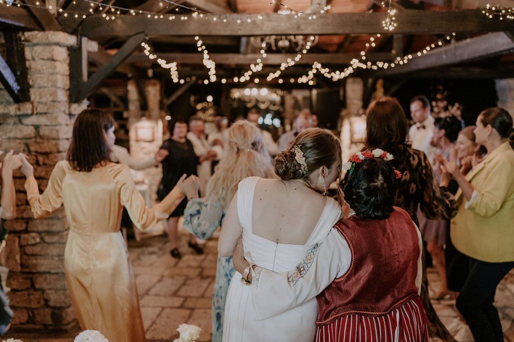 Wedding reception dance floor filled with guests celebrating under warm lighting.