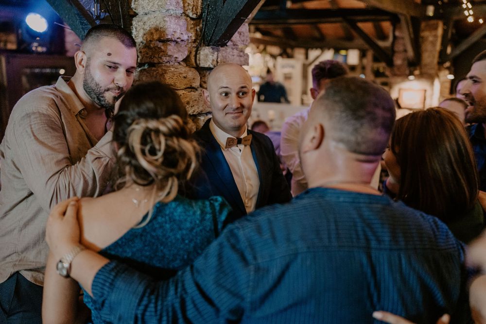 Guests mingling and socializing during an evening celebration under mood lighting.