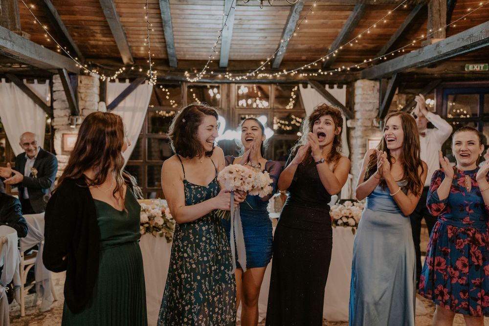 Group of party guests celebrating and dancing at an indoor reception venue.