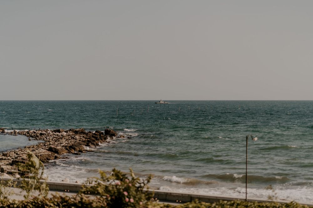Panoramic view of a rocky beach coastline with waves rolling in.