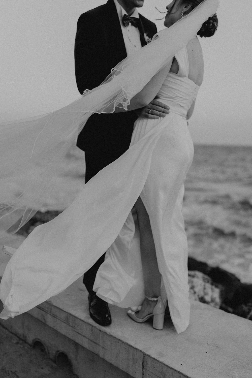 Black and white photo of formal dance steps near ocean.