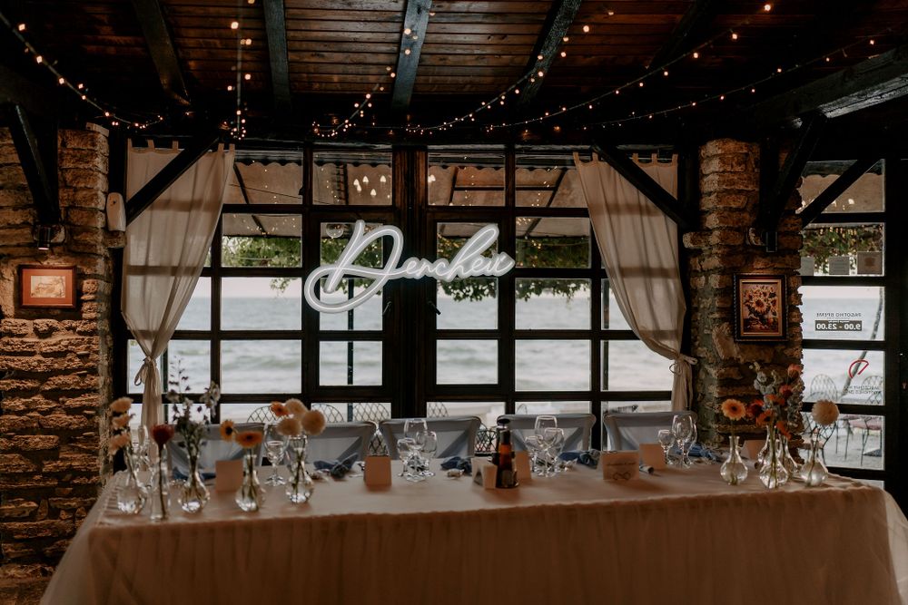 Rustic barn wedding venue decorated with twinkling string lights and exposed wooden beams.