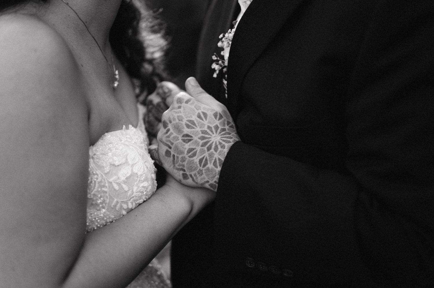 Close-up black and white detail shot of bride and groom's wedding attire.