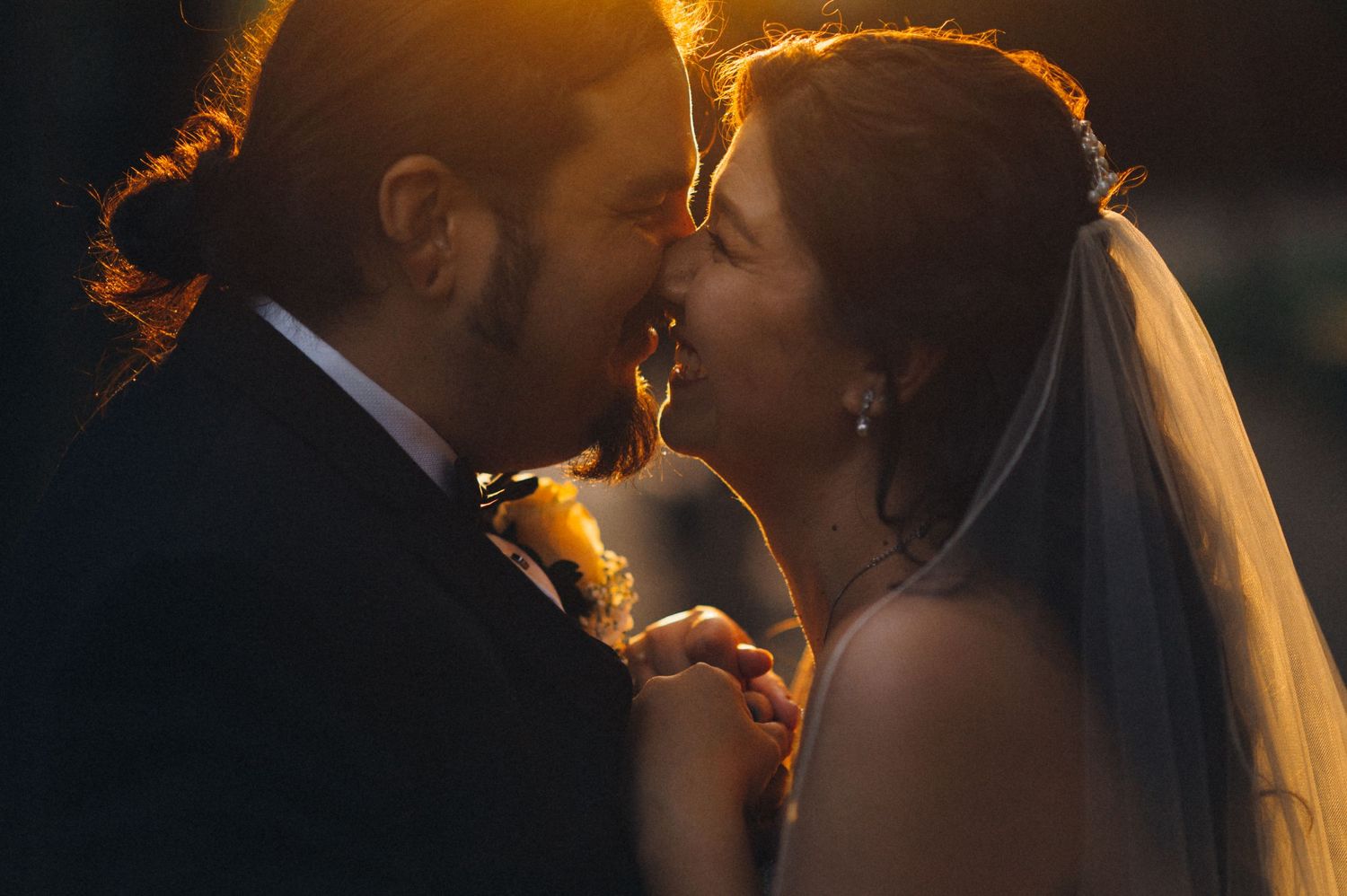 Golden hour wedding portrait captures intimate moment between newlyweds.