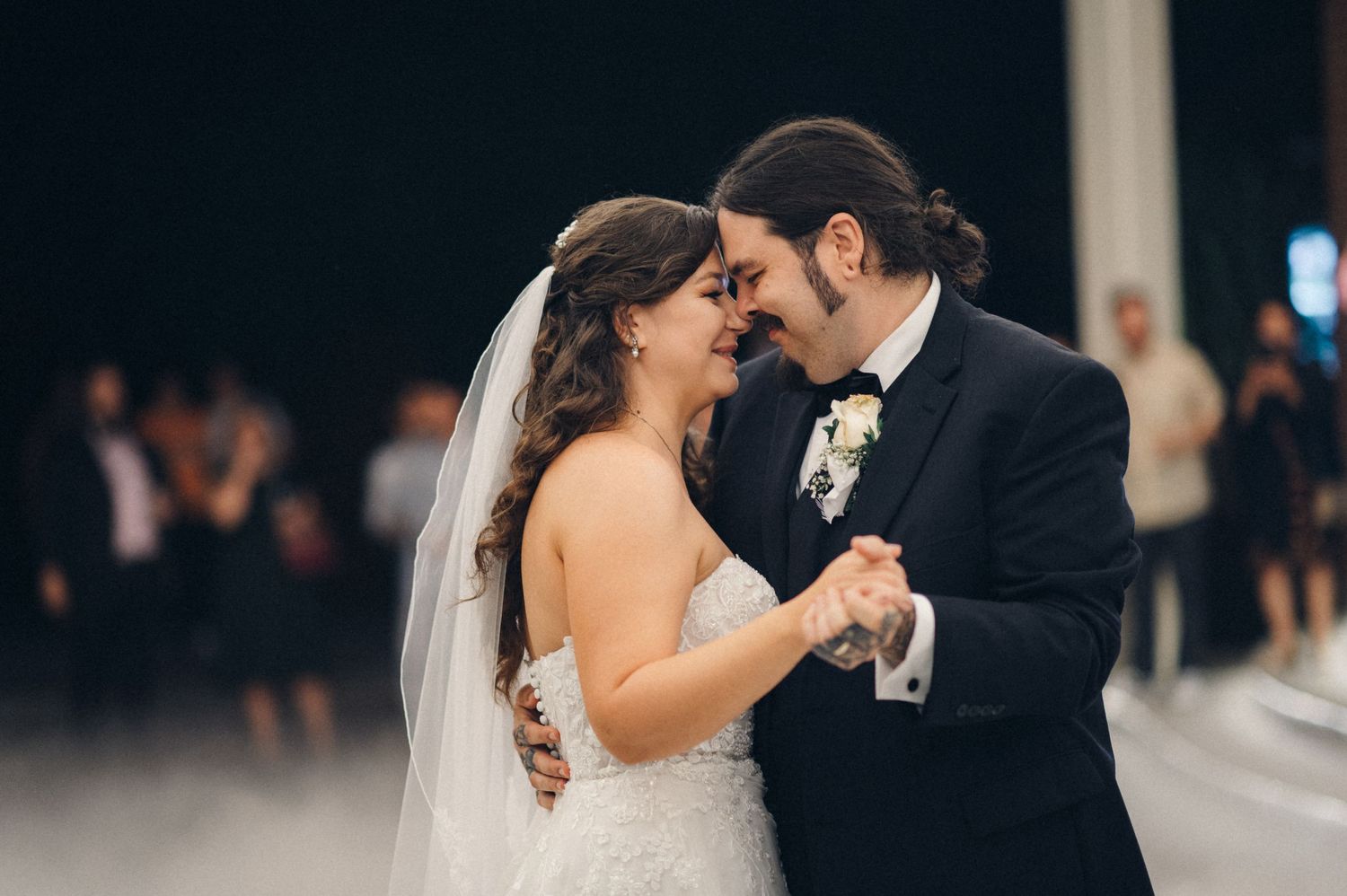 Couple shares a romantic moment while dancing at their wedding reception.