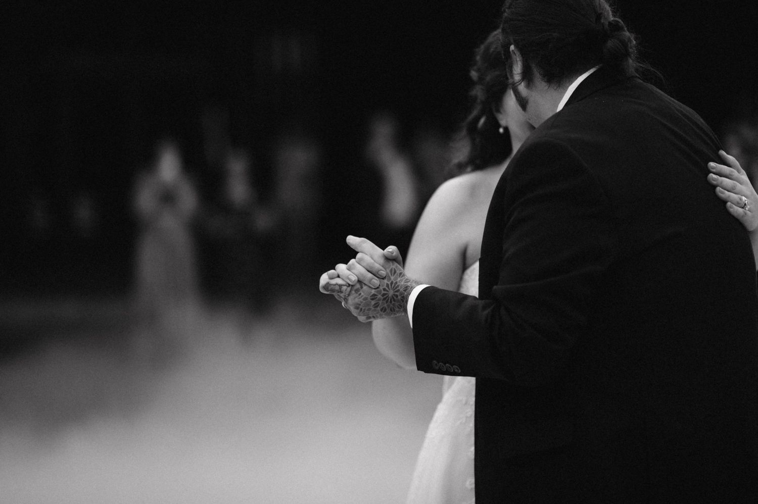 A tender moment between newlyweds dancing in black and white.