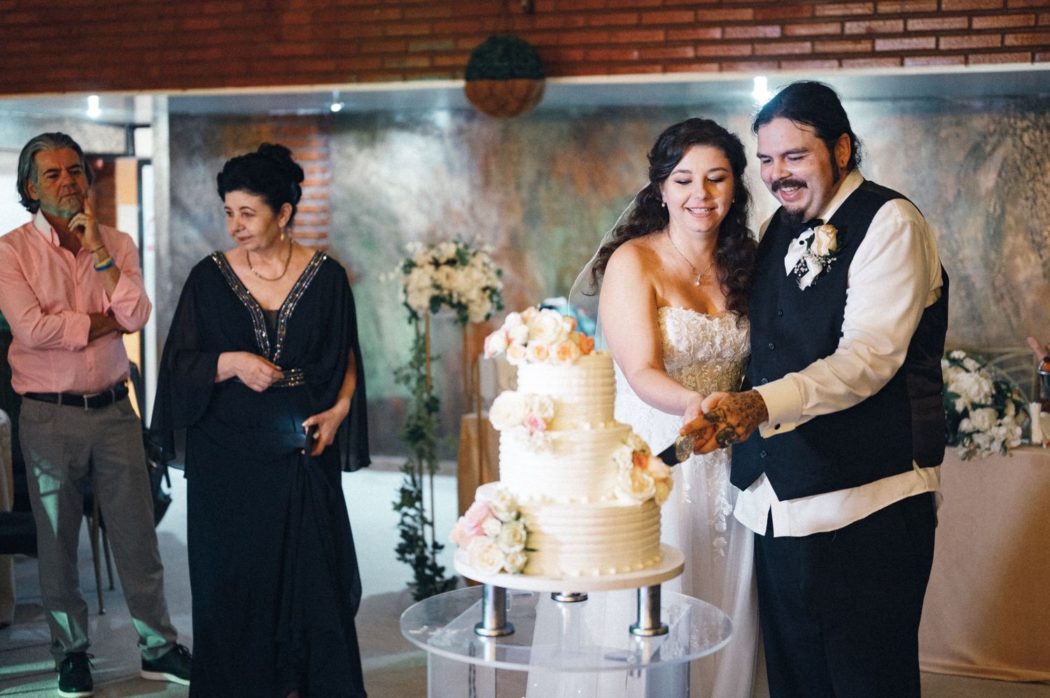 Wedding reception scene showing cake cutting celebration with guests watching.