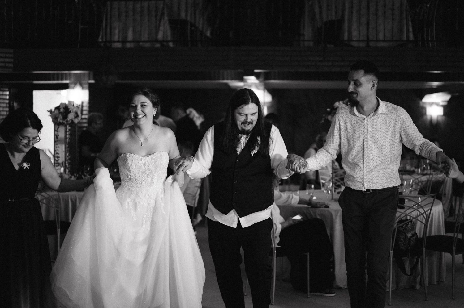 Wedding celebration with dancing and joyful movement captured in black and white.