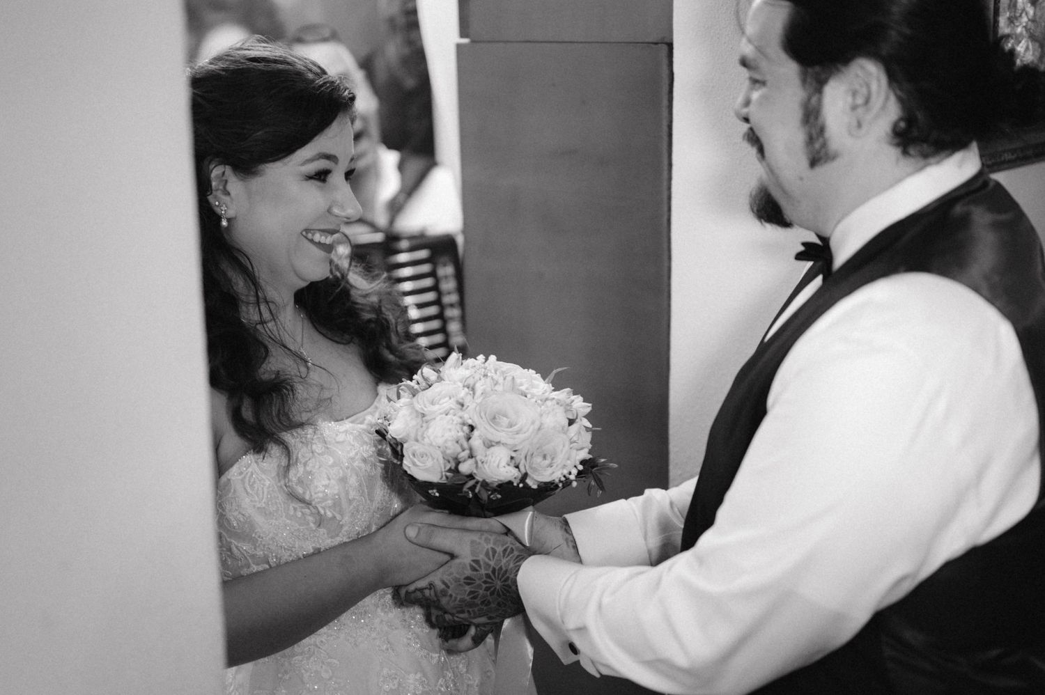 Black and white photo of a wedding bouquet exchange between bride and groom.