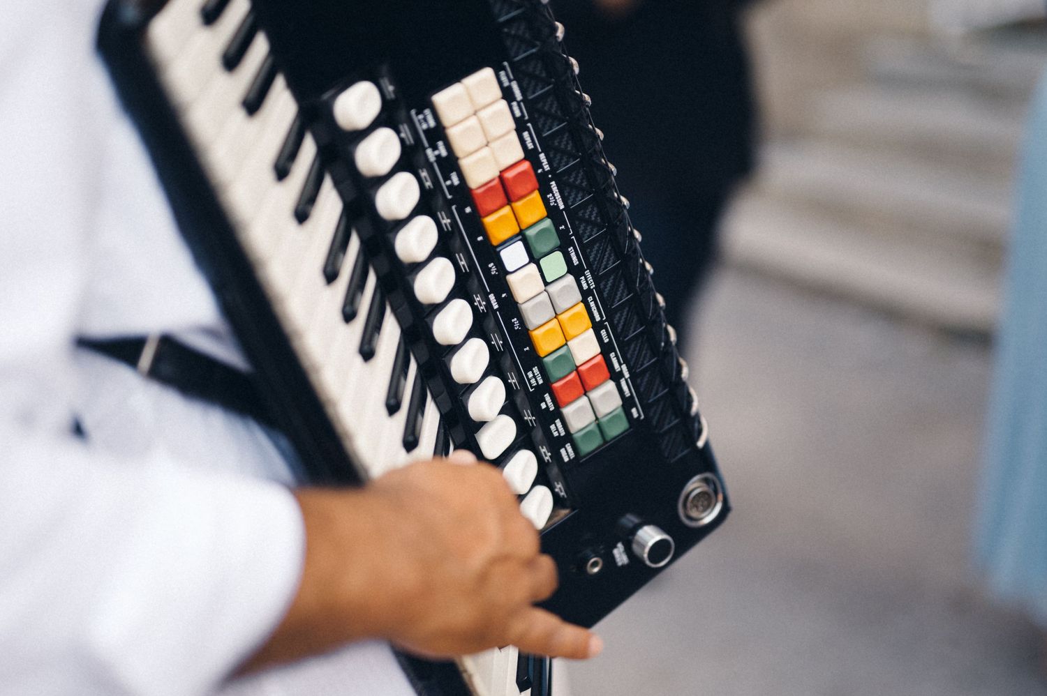 Close-up shot of colorful buttons on a black accordion keyboard during a performance.