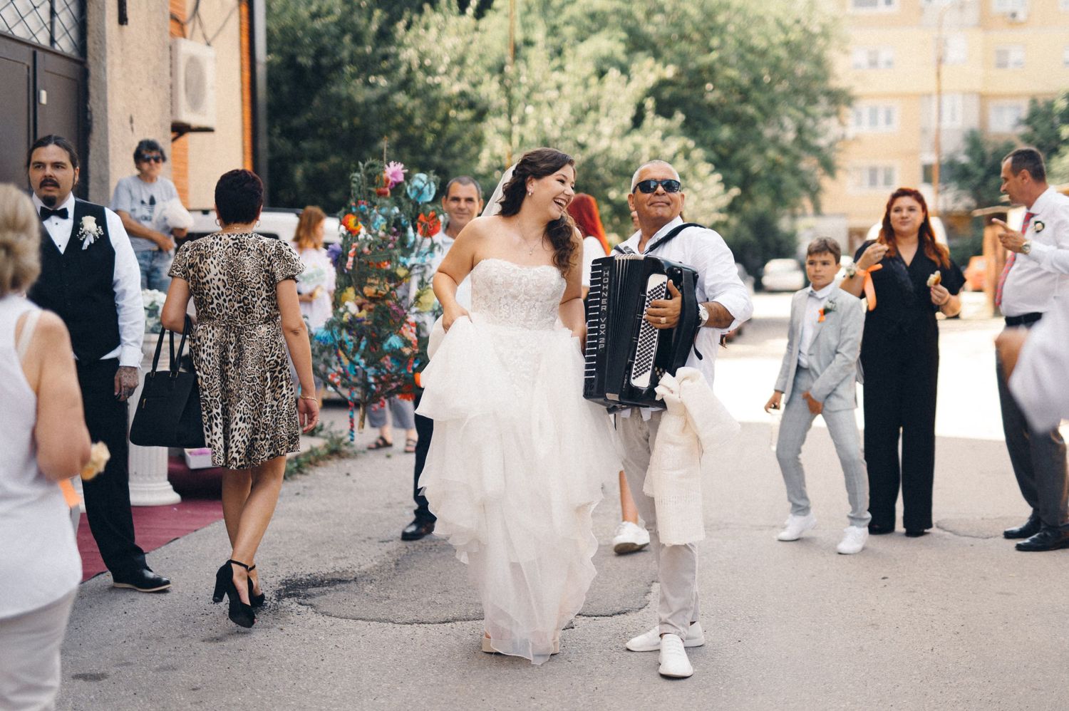 Wedding celebration in the street with guests dancing and enjoying the festivities.