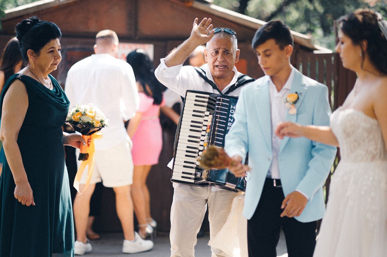 Wedding celebration with an accordion player entertaining guests outdoors.