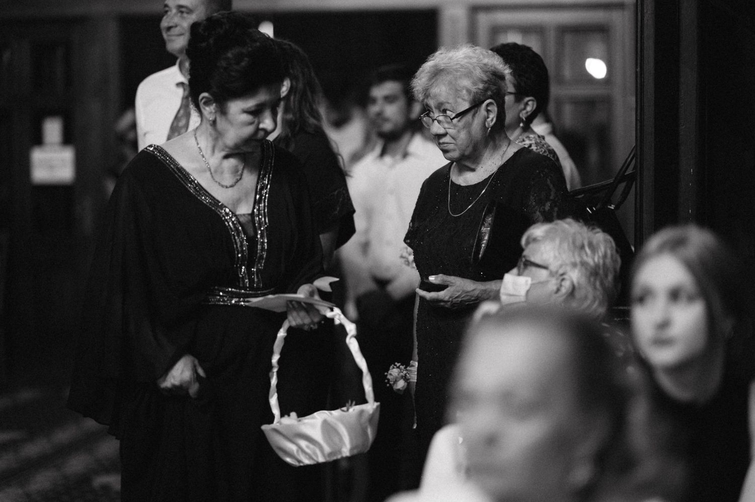 Black and white image of attendees gathered with a decorative basket at an event.