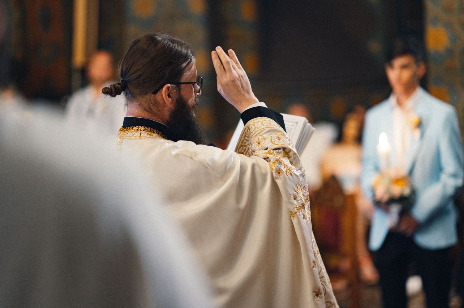 Orthodox priest raising his hands during a religious ceremony.