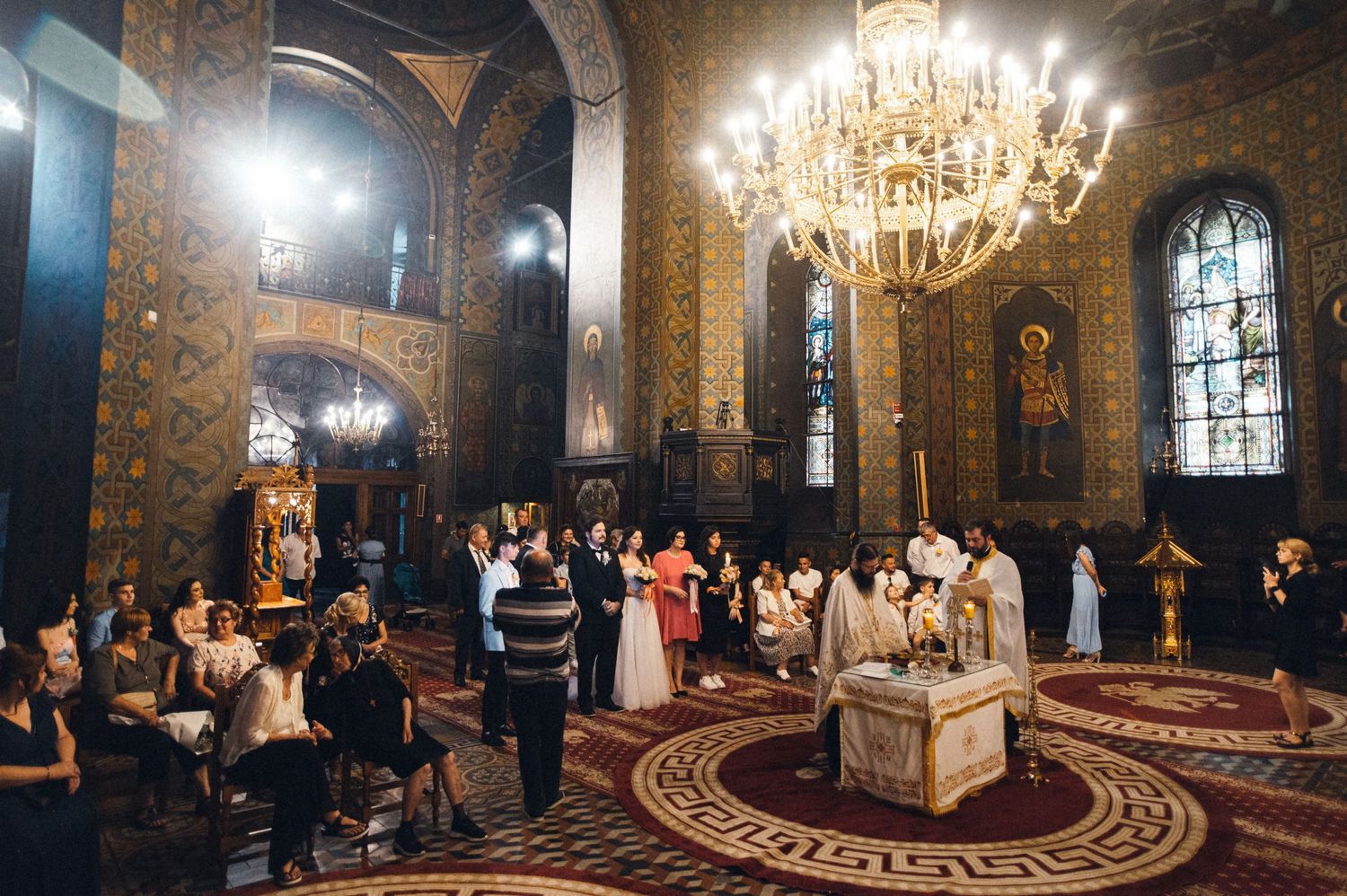 Elegant church interior with crystal chandelier during an orthodox wedding ceremony.