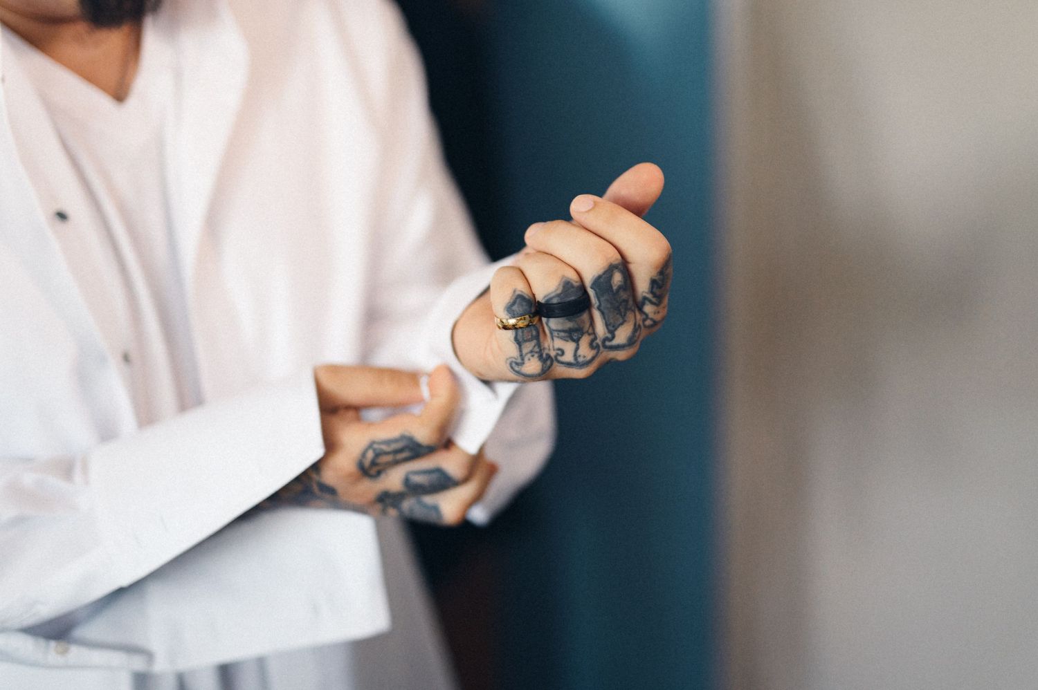 Close-up of tattooed hands adjusting formal wear.
