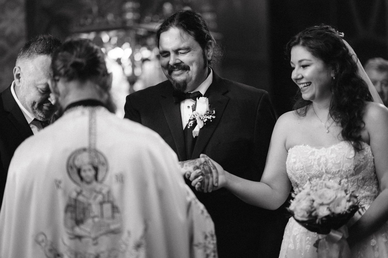 Wedding ceremony in progress with priest in traditional orthodox robes.