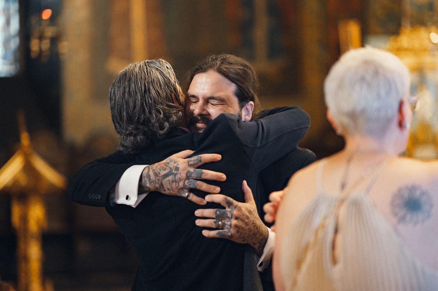 Emotional embrace shared during a wedding ceremony in an elegant church interior.