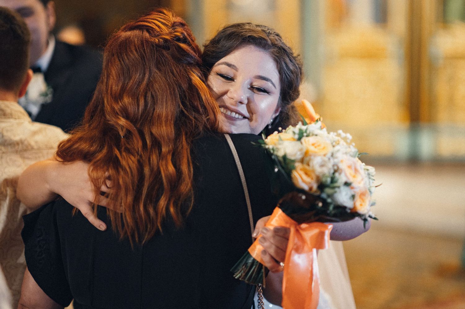 Two people sharing a warm hug and smiles during a celebratory moment.