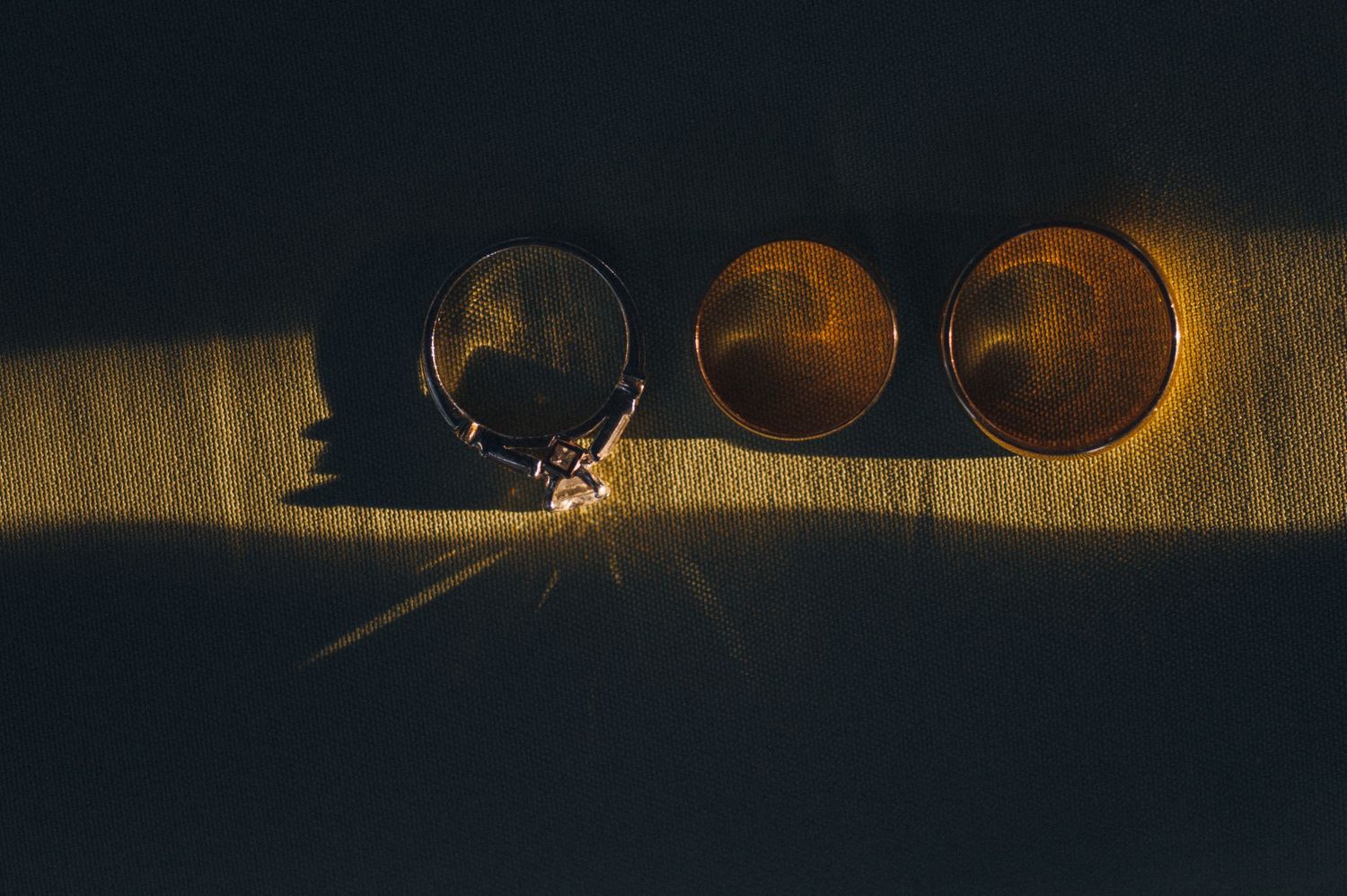 Wedding rings casting dramatic shadows in artistic lighting.