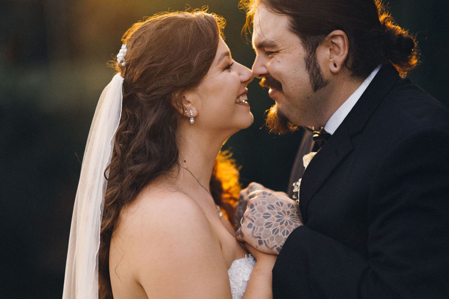 An intimate close-up of newlyweds sharing a tender moment at golden hour.