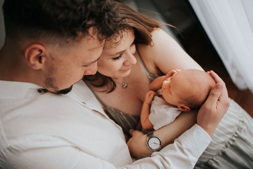 mama i tata przytulają dziecko - sesja rodzinna Kraków