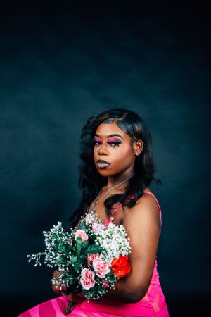 Fashion photo series with flowers showing dramatic angles and pink gown against dark background.