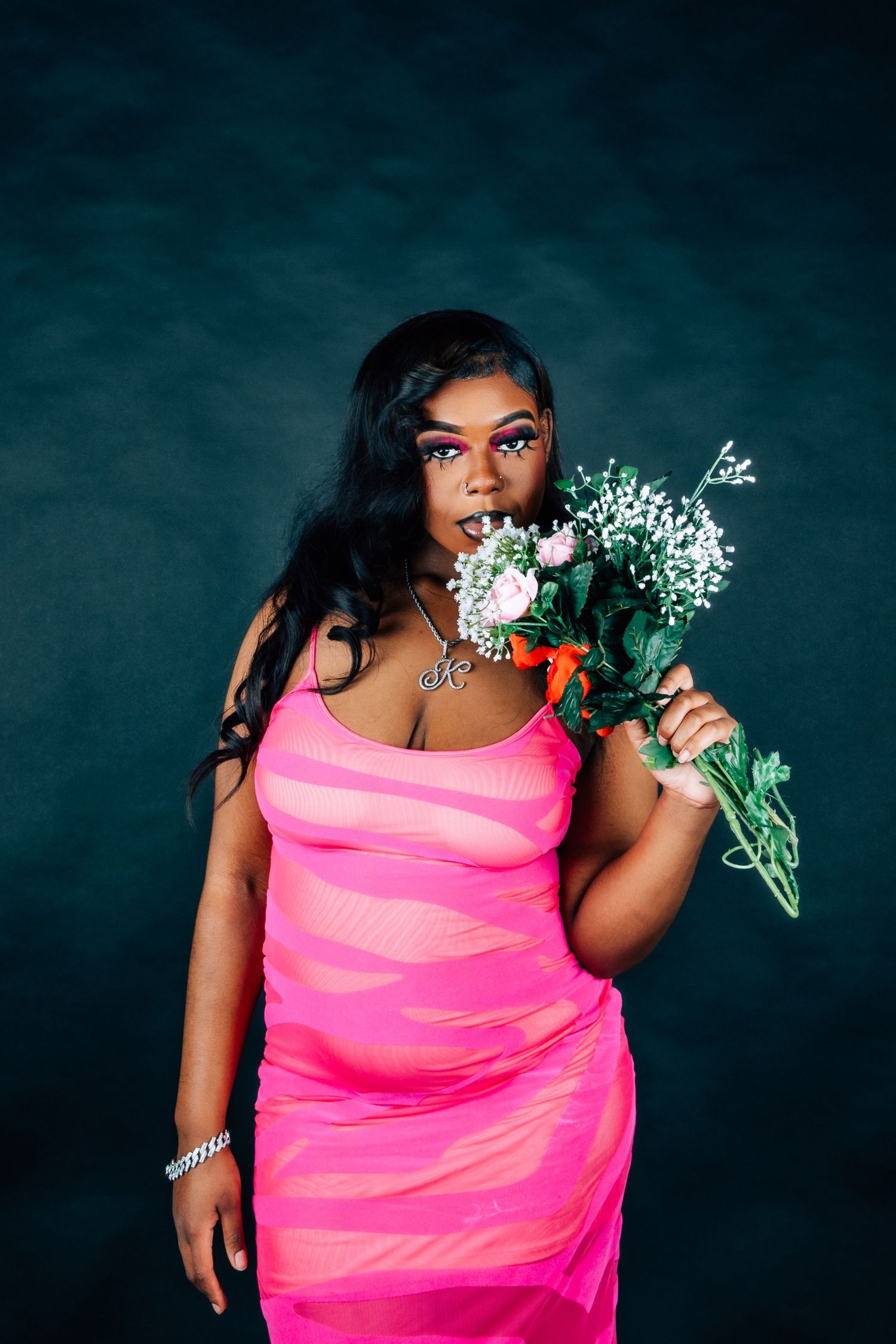 Fashion series with model in hot pink dress posing with white and pink flowers.