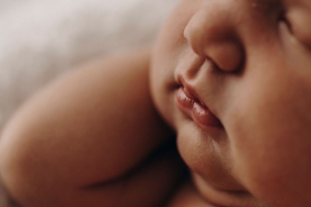 Close-up macro photograph of baby's lips and nose showing delicate facial features.