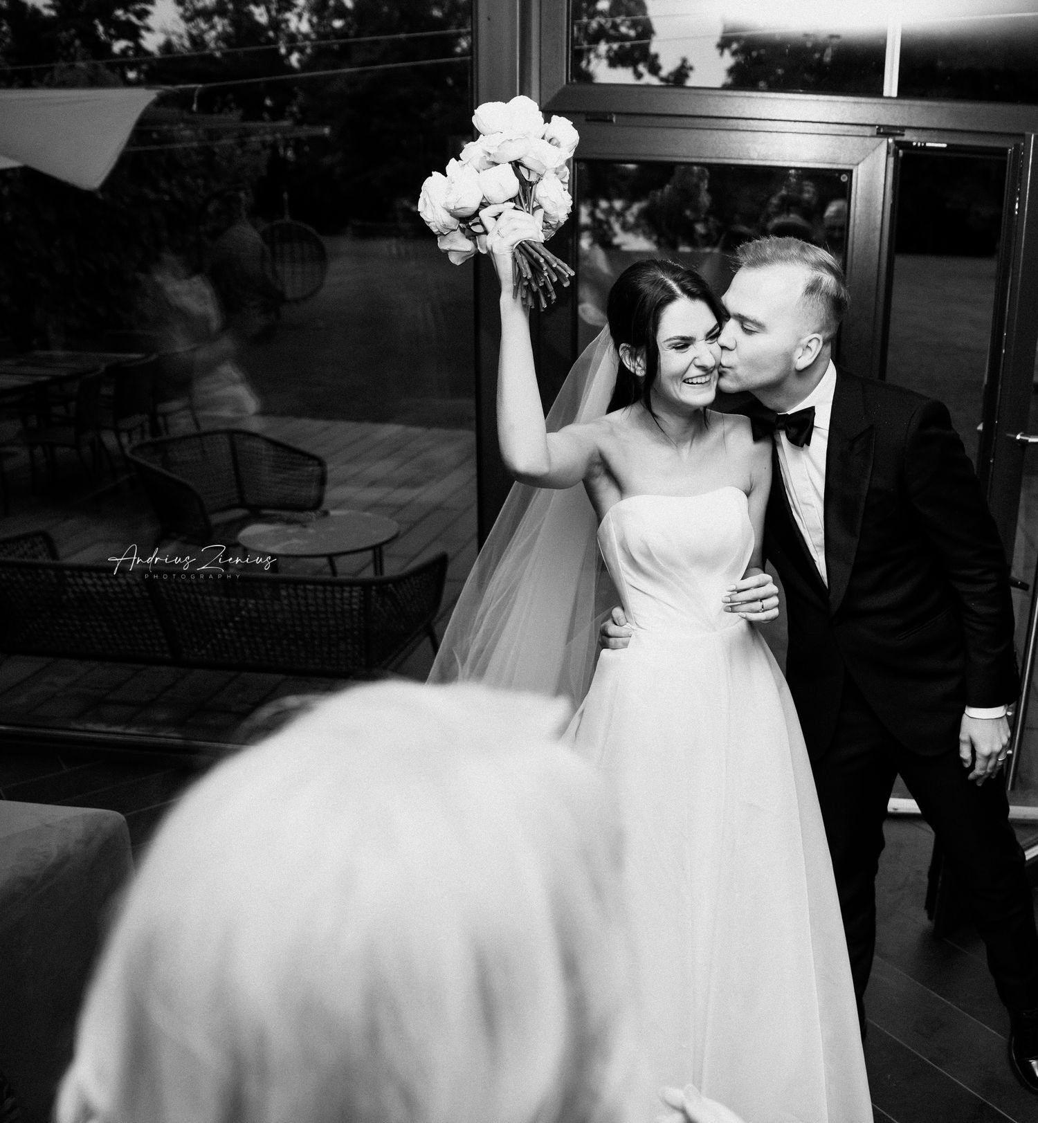 Bride in white dress holds bouquet while sharing intimate moment during wedding celebration.