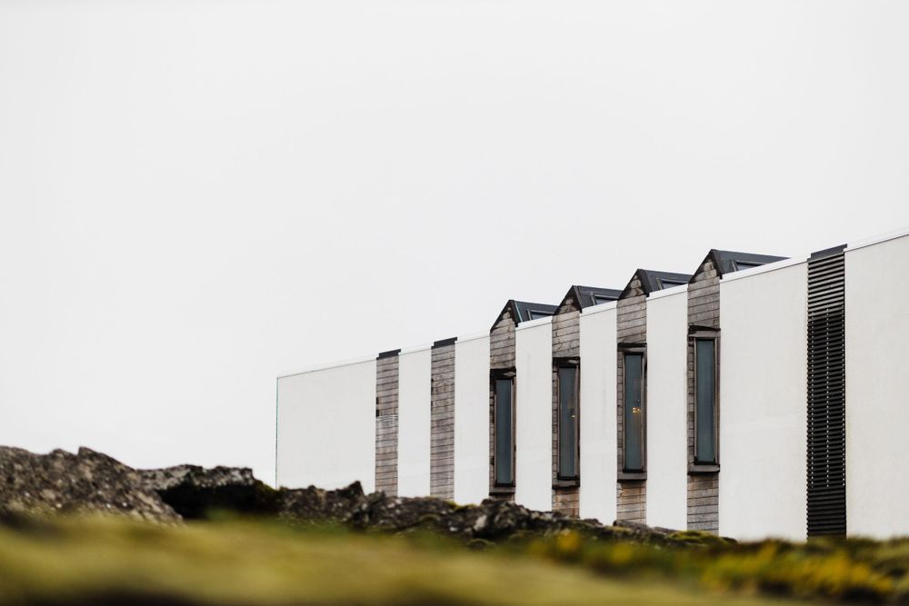 Modern white buildings with black accents line up against an overcast sky.