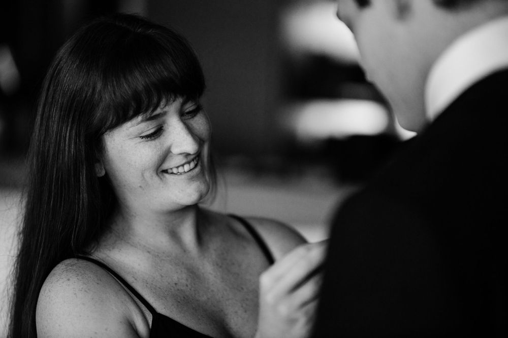 Candid black and white photo of couple sharing intimate moment.