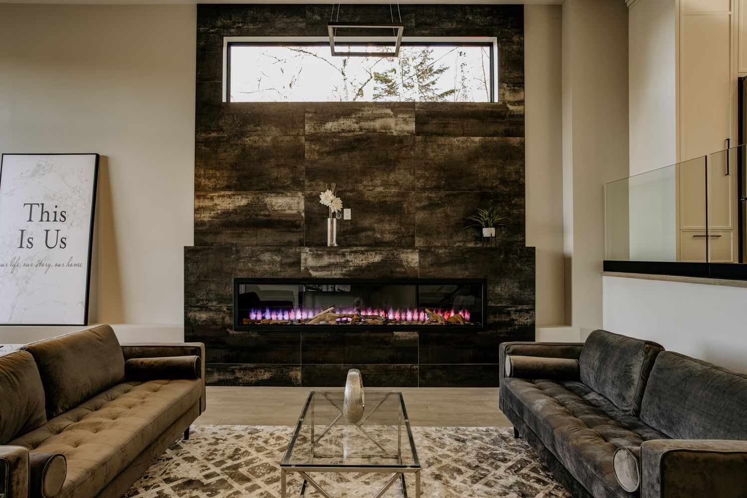 Modern living room with dark wood accent wall, two gray couches, and decorative lighting.