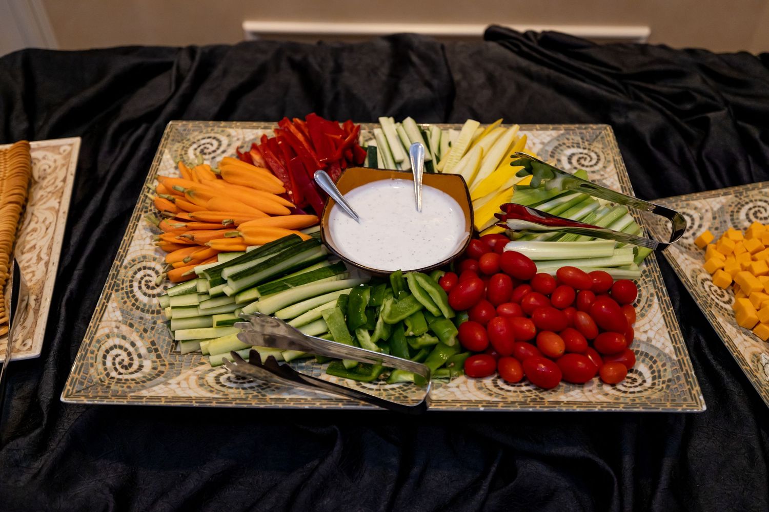 Colorful vegetable crudité platter arranged in a circular pattern with dip in the center.