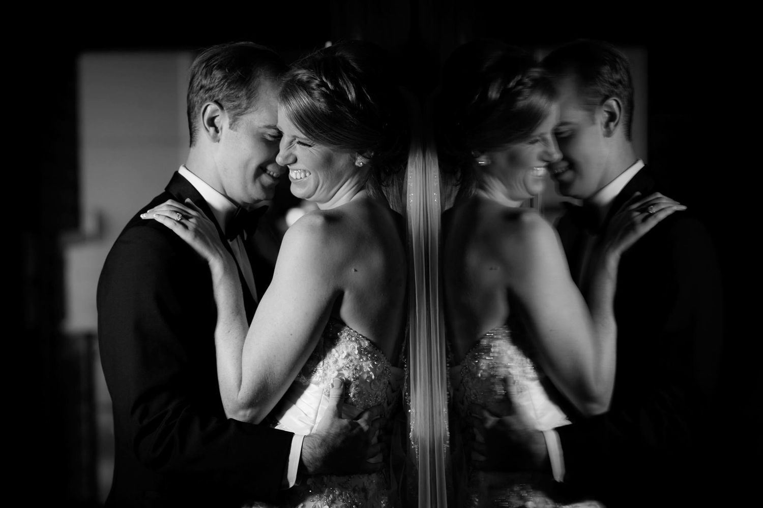Bridal couple snuggles in mirror reflection