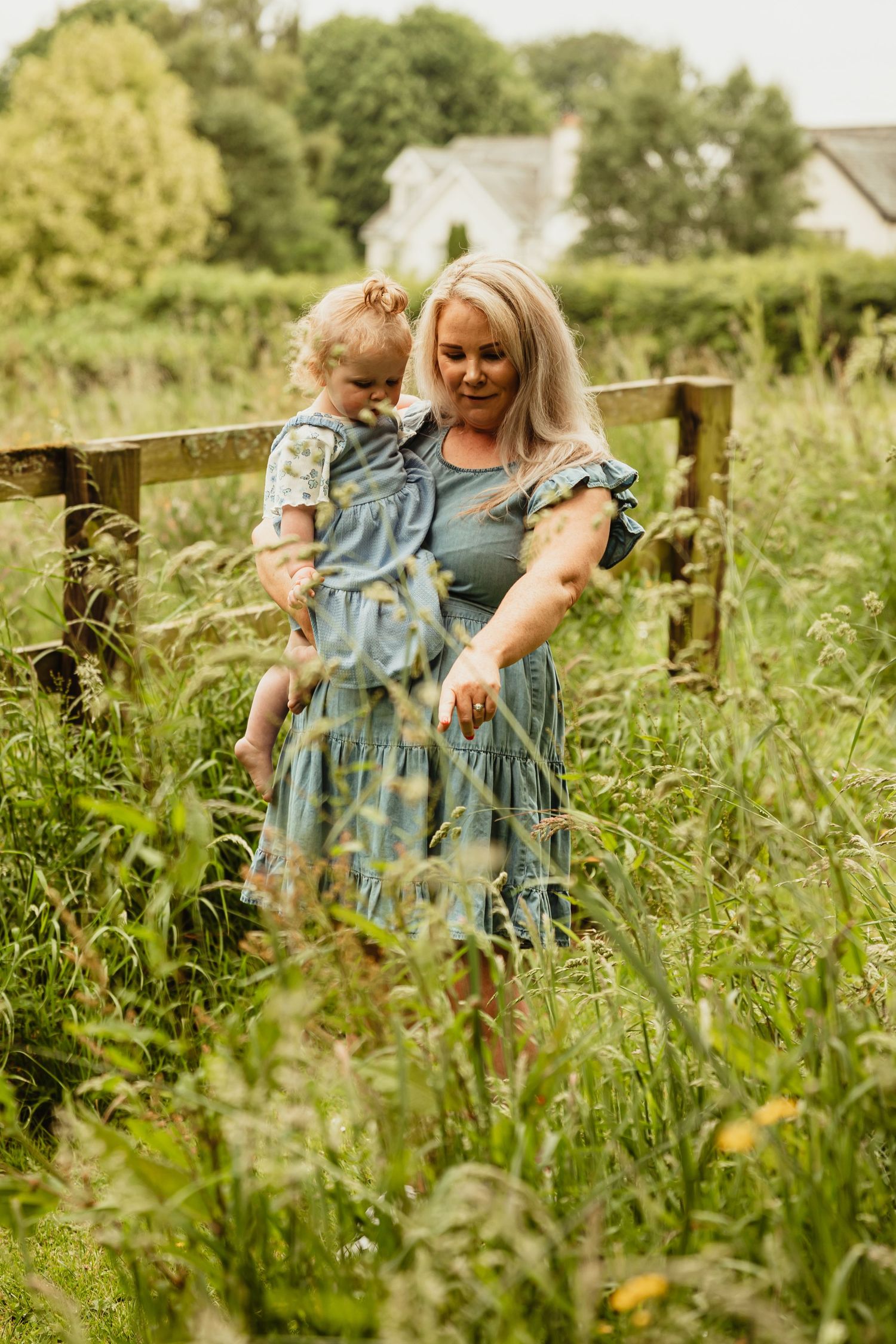 Toddler in mothers arms in wildflowers