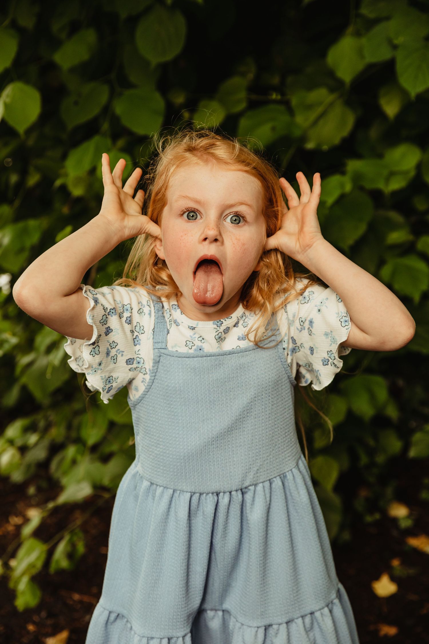 Little girl with red hair making a silly face