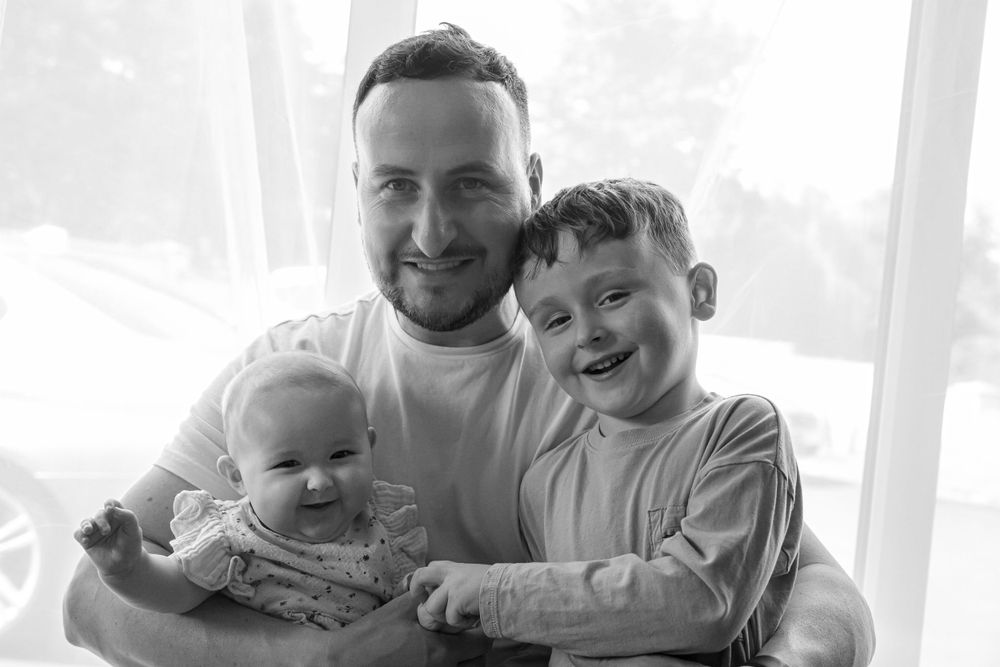 Father with young son and baby daughter. Black and white.