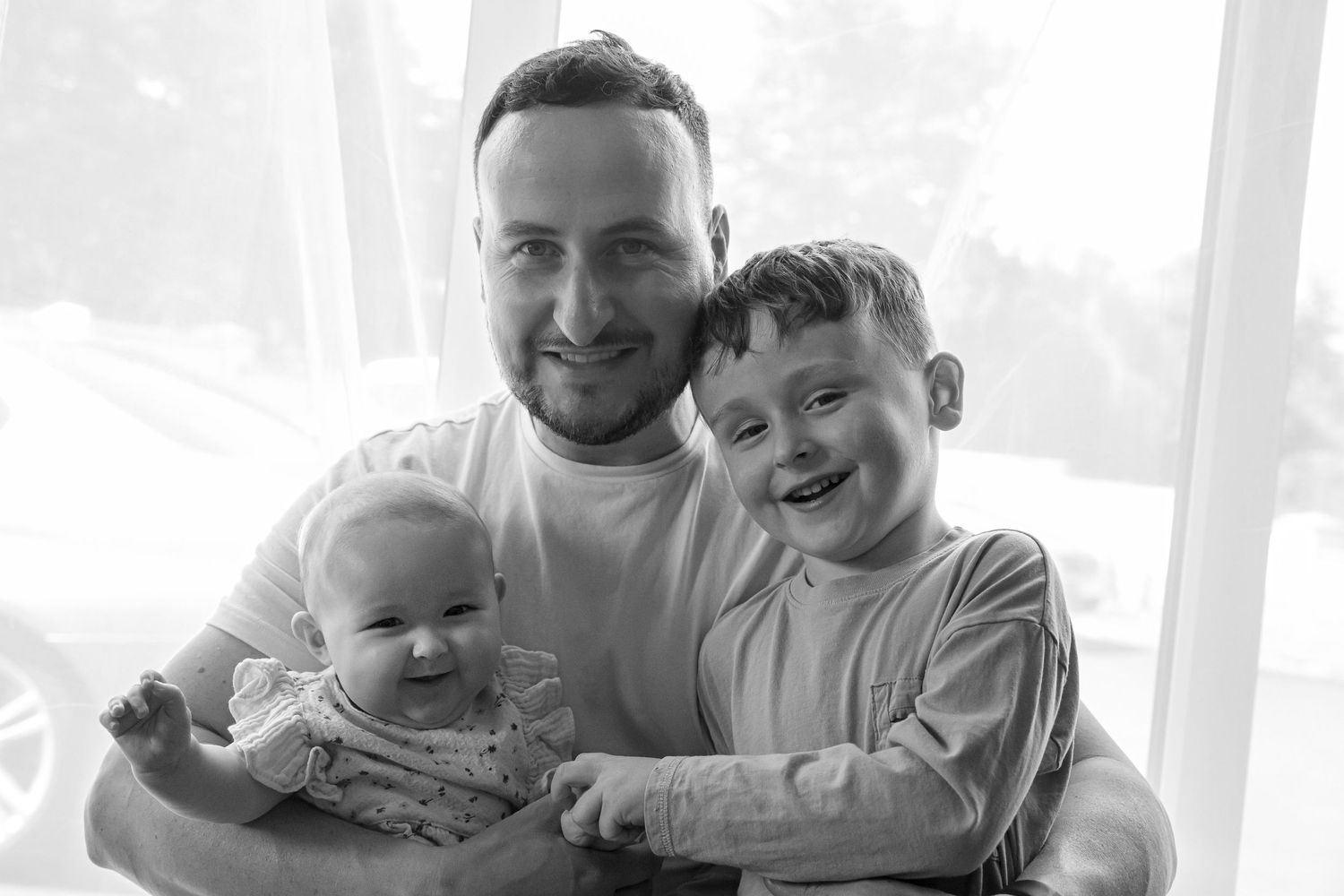Father with young son and baby daughter. Black and white.