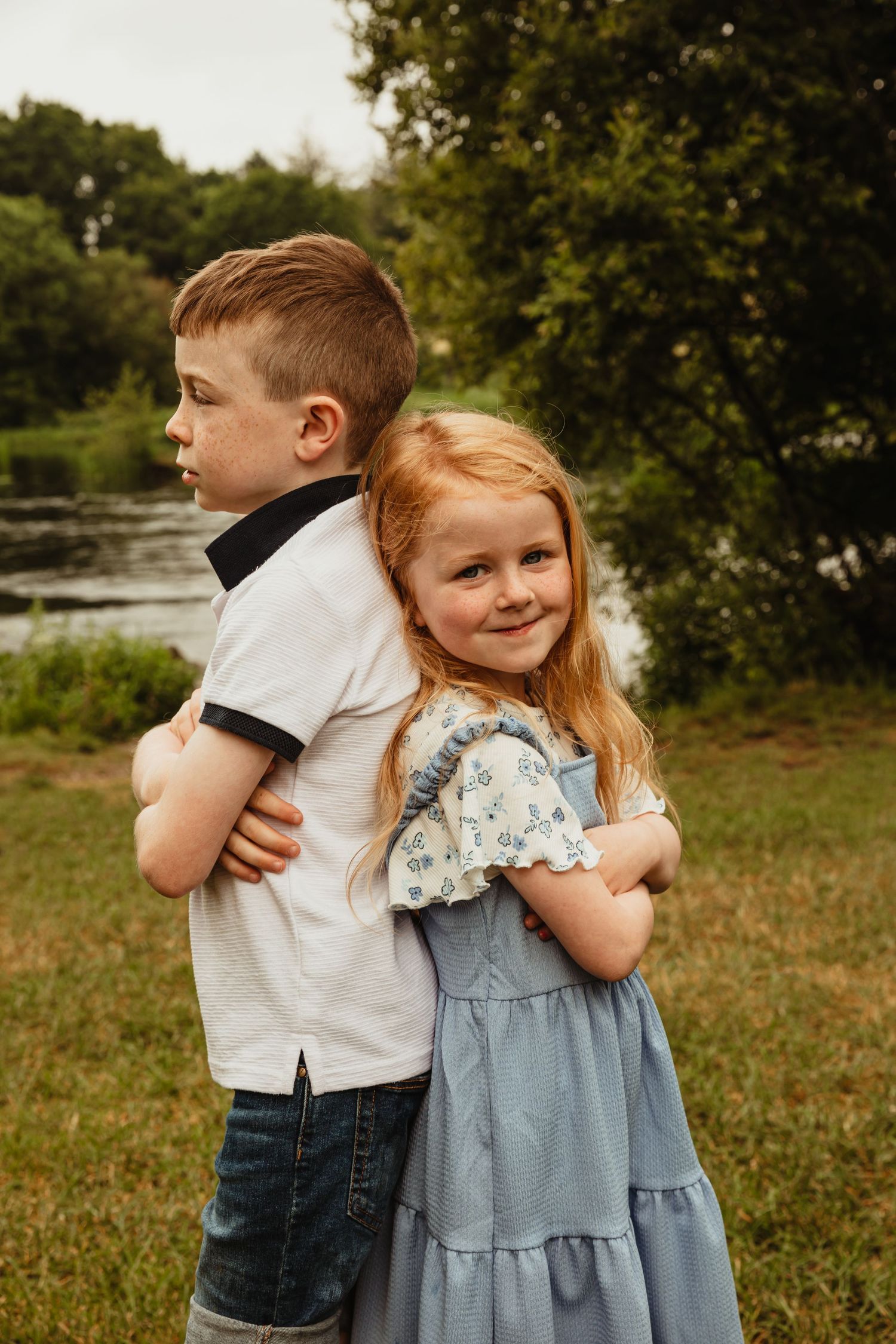 Brother and sister standing back to back