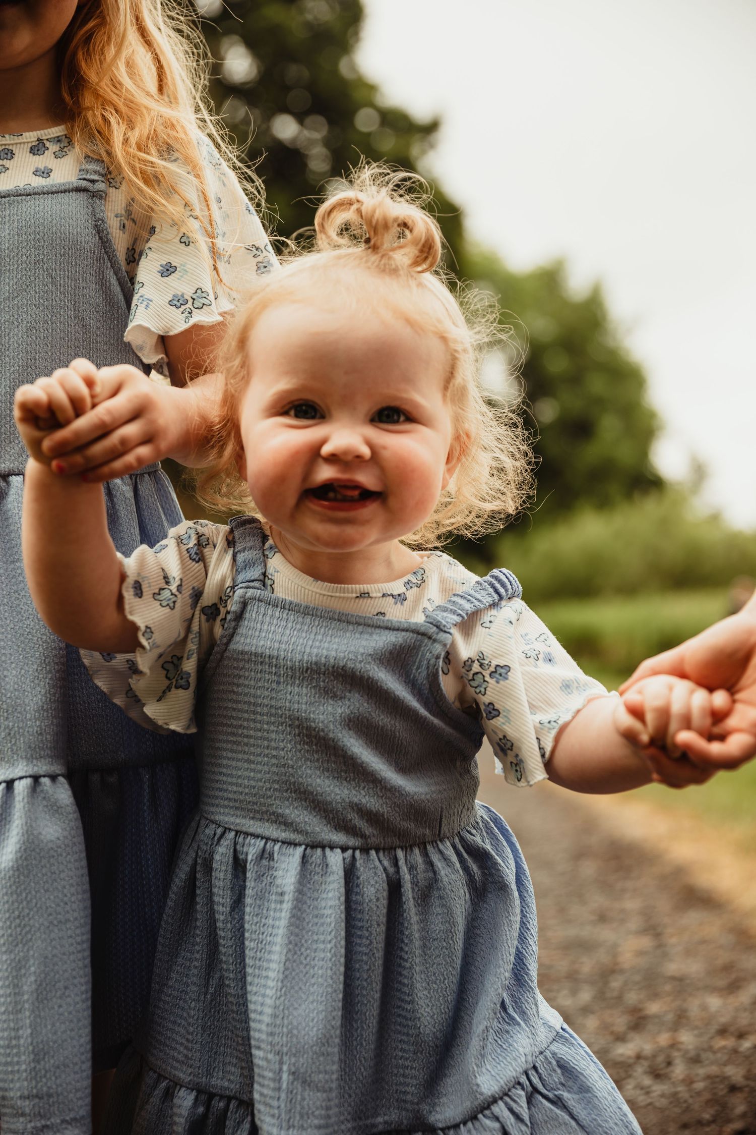 Toddler holding siblings hands