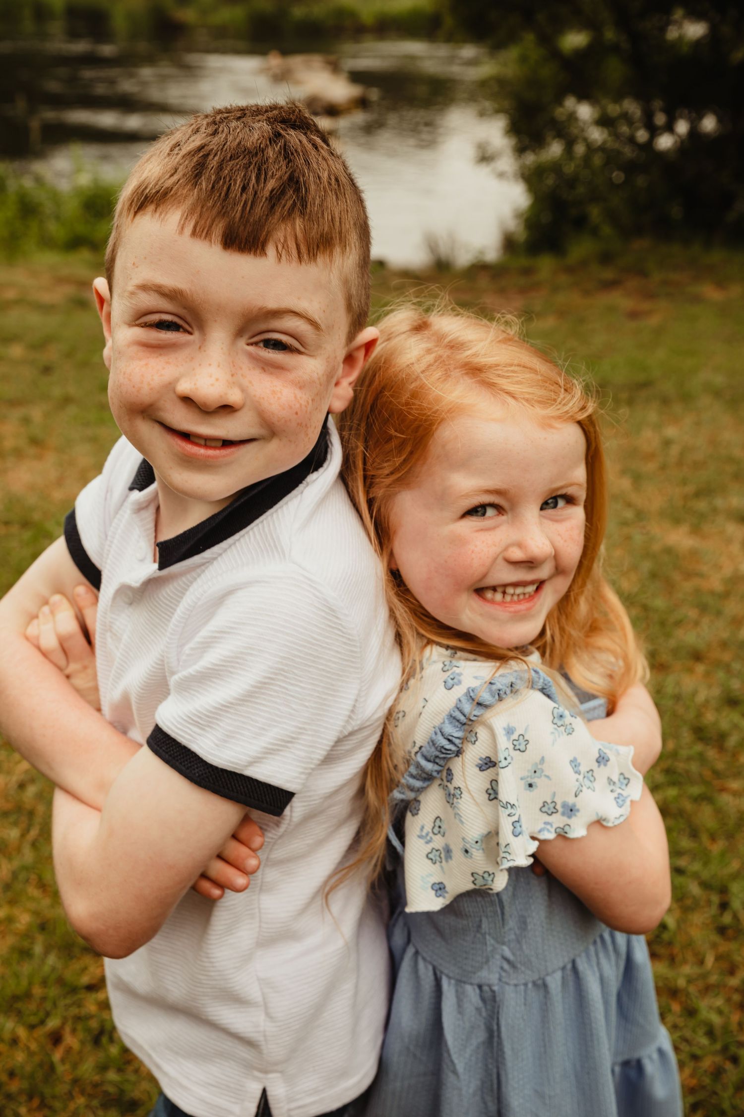 Brother and sister back to back and smiling