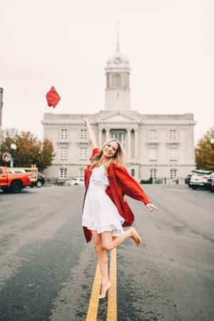 Dynamic poses captured in red jacket and white dress against architectural backdrop.