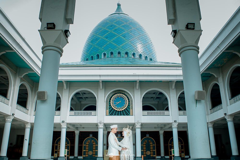 Majestic blue-domed mosque with white pillars and Islamic architectural details.
