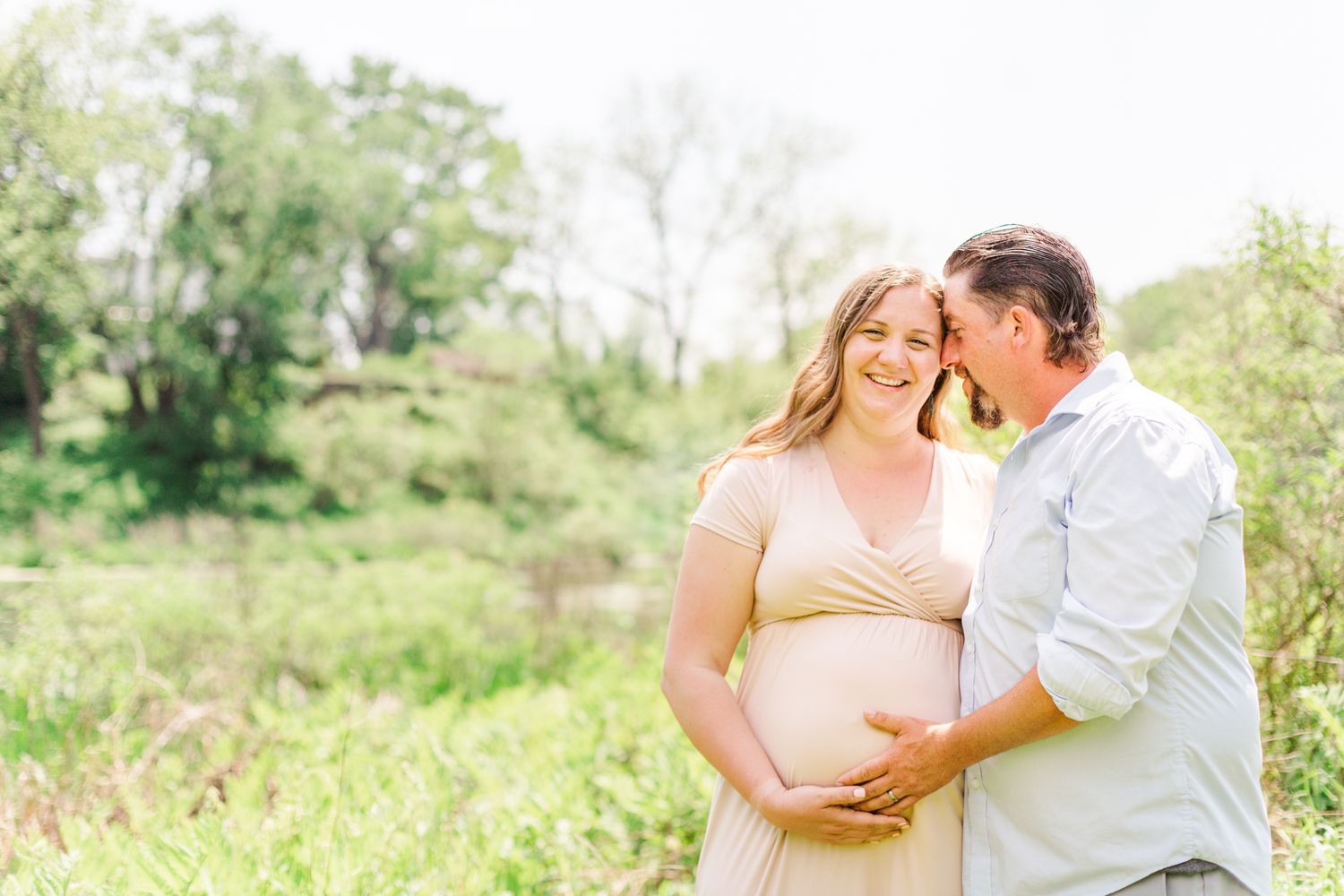 Couple smiling during a maternity photo session in New Paltz, NY with Danielle Lauren Photography