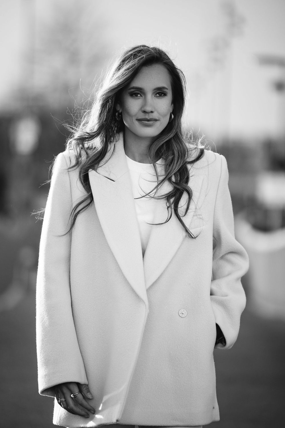 Professional fashion portrait featuring a cream colored blazer and flowing hair in black and white.