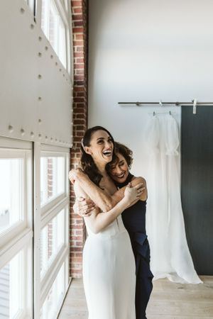 Playful wedding moments captured in a bright indoor venue with brick walls.