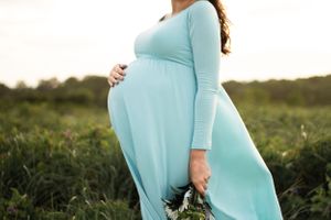 Maternity photoshoot of beautiful mama in field with flowers